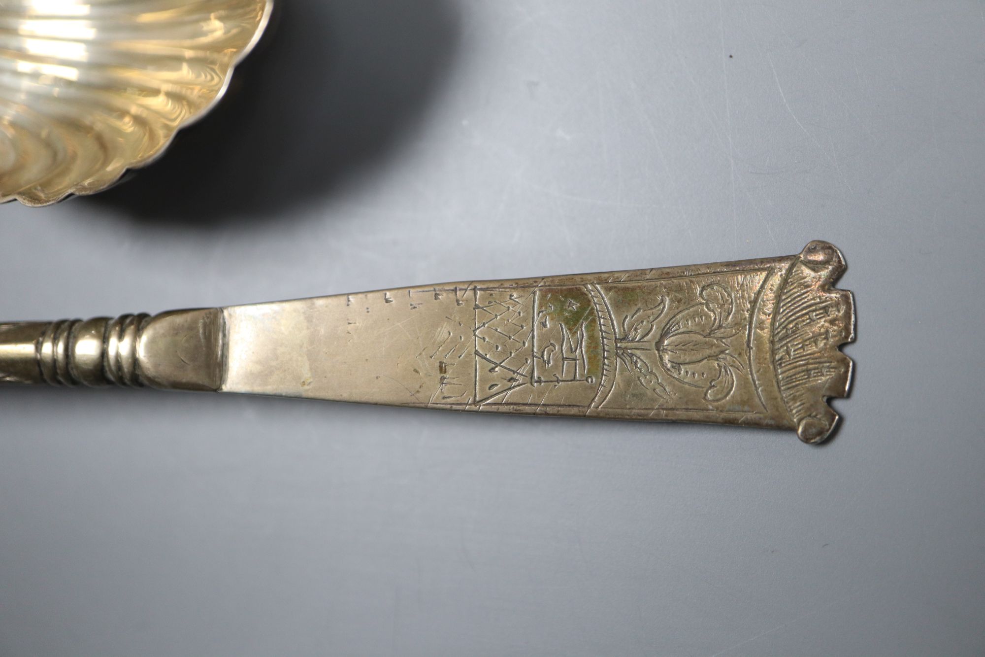 An early 18th century Dutch white metal spoon, the bowl underside monogrammed TIS-KLD and two silver caddy spoons.
